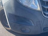 the front end of a white van parked in a parking lot