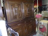une grande armoire en bois au milieu d'une pièce remplie de cartons