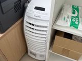 un petit climatiseur posé à côté d'une petite armoire