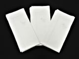 trois feuilles de papier blanc posées sur une surface noire