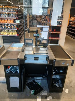 une photo d'une épicerie avec une caisse au milieu de l'allée