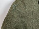 a close up of a green jacket with holes on it