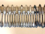 de nombreuses fourchettes et cuillères alignées sur une table