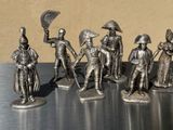 five figurines of men dressed in different costumes