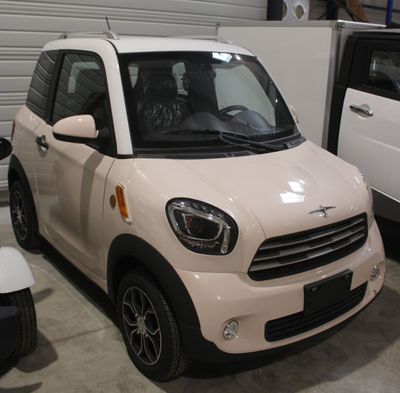 une petite voiture blanche garée dans un garage à côté d'une voiture blanche
