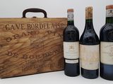 trois bouteilles de vin devant une caisse en bois