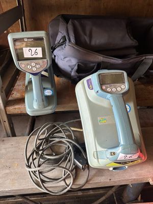 deux appareils portables posés sur une étagère à côté d'un sac