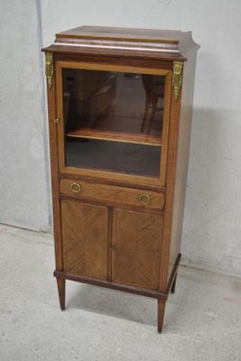 un meuble en bois surmonté d'une porte en verre