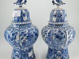 deux vases bleus et blancs sur lesquels sont perchés des oiseaux