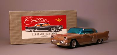 toy car in front of a cardboard box with a picture of a cadillac