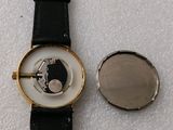 a watch that is sitting next to a coin
