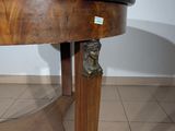 a wooden table with a black top and a lion head on it
