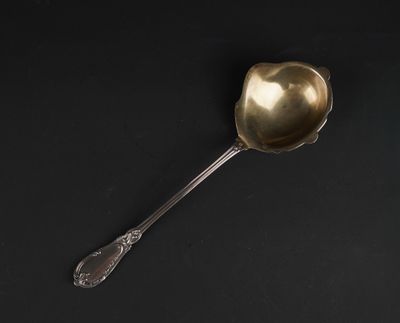 a silver spoon with a spoon handle sitting on a black surface