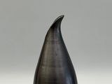 a black vase sitting on top of a white table