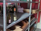 many shelves with bottles of wine on them in a room
