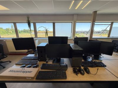 un bureau sur lequel sont posés plusieurs écrans d'ordinateur