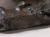 a bronze statue of a duck with a wreath on it ' s head