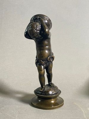une statue en bronze représentant un garçon tenant un ballon de basket