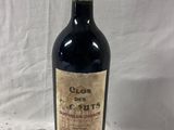 a bottle of red wine sitting on top of a white table
