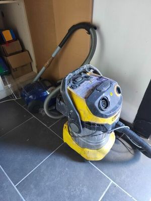un aspirateur jaune et noir posé par terre dans une pièce