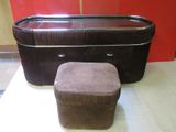 un pouf marron posé à côté d'une commode dans une pièce