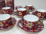 several cups and saucers are sitting on a table with a pitcher