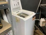 a washer and dryer in a room with shelves