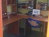 a room with a desk, shelves, and a chair in it