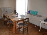 une table et des chaises dans une pièce, avec un radiateur en arrière-plan