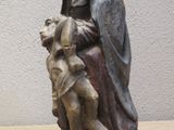 statue of a woman holding a child on a wooden table