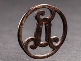 a small metal object with a letter inside of it