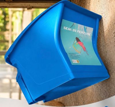 a blue trash can hanging on the side of a building
