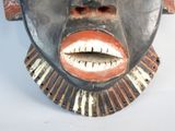 a close up of a wooden mask on a white background