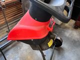 une tondeuse à gazon rouge et noire garée dans un garage