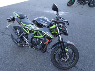 une moto noire et verte garée sur le bord de la route