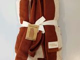 three brown and white towels tied together on a white surface