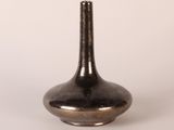 a black vase that is sitting on a white surface