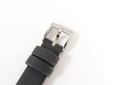 black leather watch strap with silver buckle on a white surface