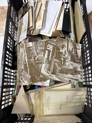 a black basket full of books and papers on the floor