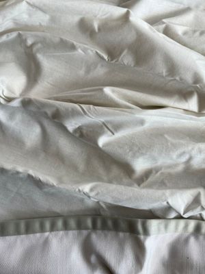 un lit recouvert d'une couette blanche et de draps blancs