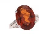 une bague sertie d'un saphir orange de taille ovale et de diamants
