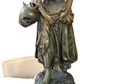 a statue of a woman holding a clock on top of a table