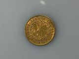 a gold coin sitting on top of a white surface