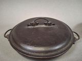 a large metal pot with a handle on a table