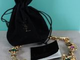 a close up of a bracelet with a bag on a table