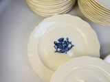 de nombreuses assiettes blanches ornées de motifs bleus, disposées sur une table