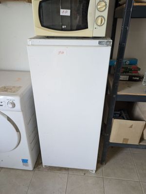 a microwave sitting on top of a refrigerator next to a washing machine