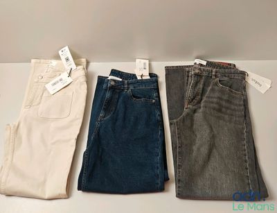 Trois paires de jeans pour homme sont alignées sur une table
