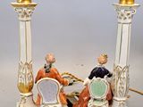 pair of porcelain figurines of two men sitting at a table