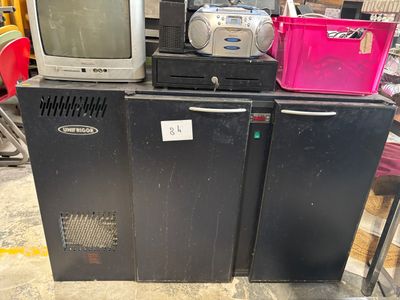 un téléviseur posé sur un réfrigérateur dans une pièce